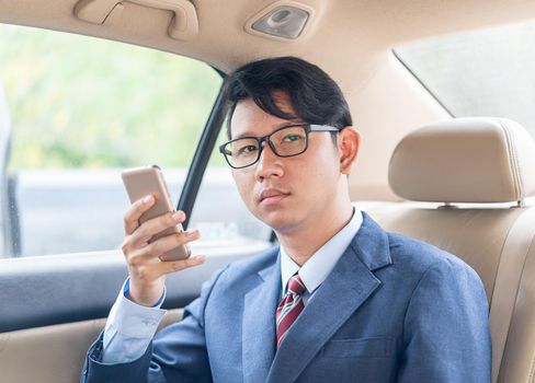 Young asian business men portrait in suit  talking on the phone in car