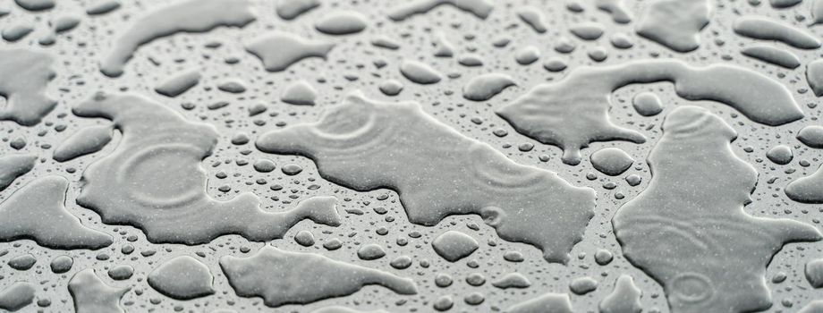 Drops of water on the car after rain. Water drops on top of metal surface.