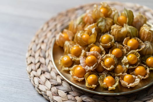 Top view pile of cape gooseberry fruit in the gold plate.