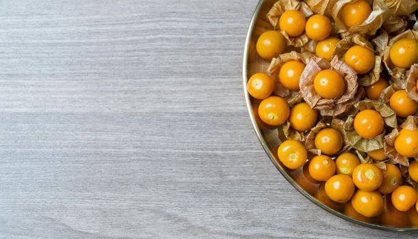 Top view pile of cape gooseberry fruit in the gold plate.