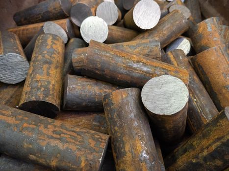 a pile of raw steel short bars cutted by saw- workpieces prepaired for forging, close-up with selective focus and background blur