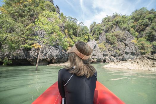 Back of woman tourist woman on a red kayak in Koh Hong, Tham Lot Cave at Hong Island in Phang-Nga Bay, Thailand.