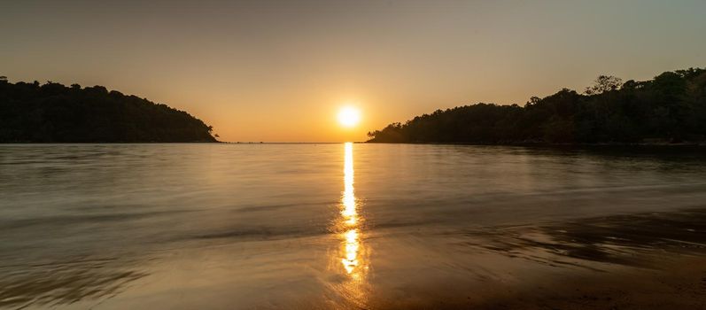 Sunset ocean view. Sun above the sea on orange sky.