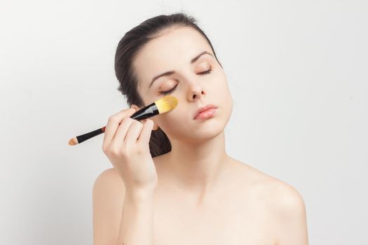 brunette brushing cream on face skin care cropped view. High quality photo
