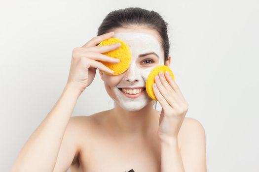 brunette naked shoulders face cream skin care. High quality photo