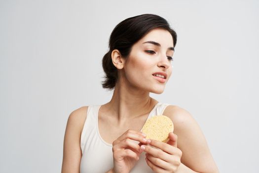 Pretty woman with sponge clean skin facial care close-up. High quality photo