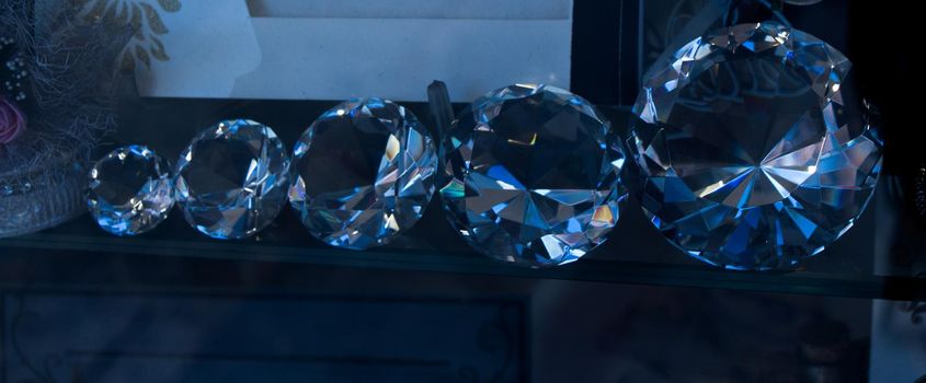 Five transparent diamonds aligned from small to big on display