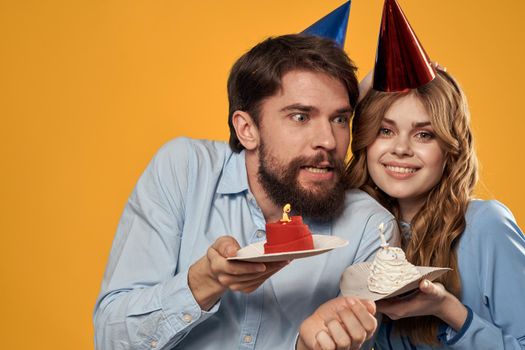 Birthday party man and woman fun yellow background cap holiday. High quality photo