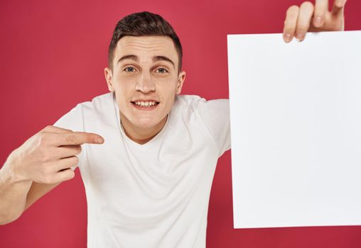 Man with a vertical sheet of paper on a red advertising background. High quality photo