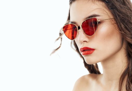 Elegant brunette lady in brown glasses on a light background. High quality photo