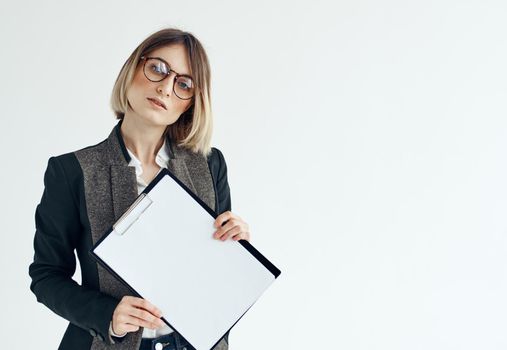 a woman in a formal suit holds a white sheet of paper in her hands Copy Space. High quality photo