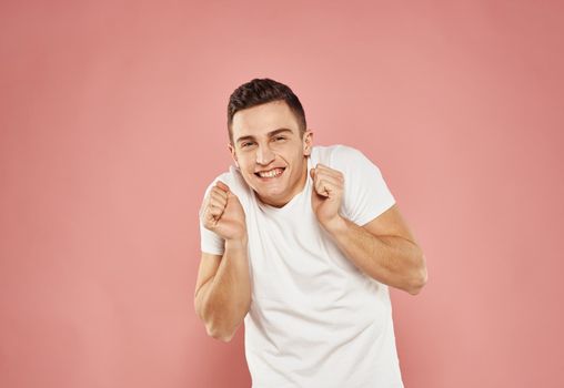 handsome man in white t-shirt lifestyle emotions pink background. High quality photo