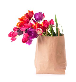 colorful tulips in a paper bag on a white background