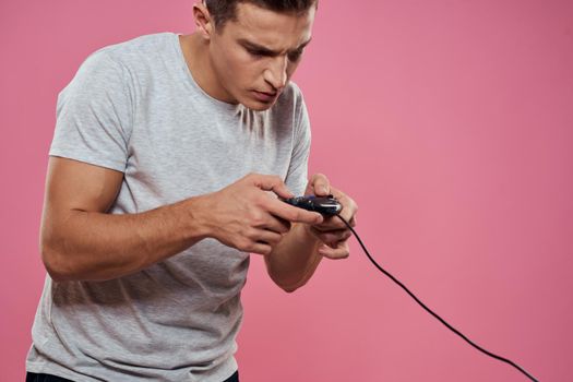 man wearing white t-shirt console joystick games craze technology pink background. High quality photo