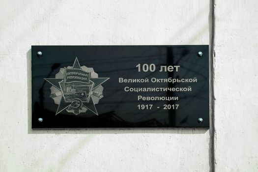 In Russian language - 100 years of the great October Revolution, on the white wall of the house.