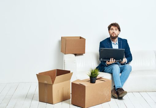 man sits on the couch with a laptop working professional . High quality photo