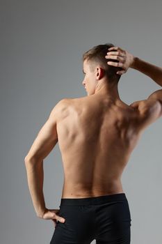 athletic male athlete posing with pumped body back view isolated background. High quality photo