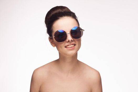 woman naked shoulders sunglasses glamor light background. High quality photo