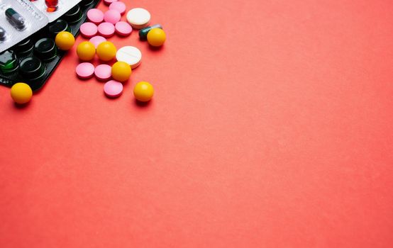 multicolored pills on red background medicine health. High quality photo
