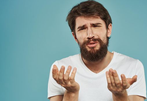 Emotional guy gesturing with his hands on a blue background Copy Space Model cropped view. High quality photo