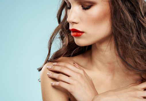 Elegant brunette woman with red lips bared shoulders and eye shadow cropped view. High quality photo