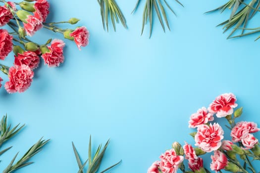 Concept of Mother's day holiday greeting gift design with carnation bouquet on bright blue table background