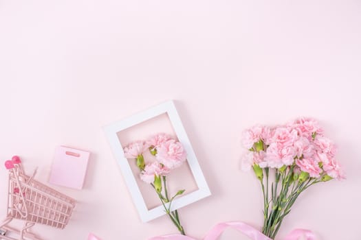 Concept of Mother's day holiday greeting design with carnation bouquet and gift on pink background