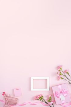 Concept of Mother's day holiday greeting design with carnation bouquet and gift on pink background