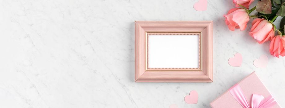 Giftbox and pink rose flower on marble white table background for Mother's Day holiday greeting design concept.