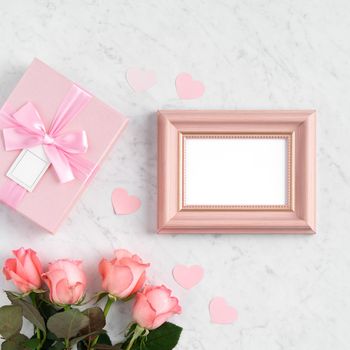 Giftbox and pink rose flower on marble white table background for Mother's Day holiday greeting design concept.