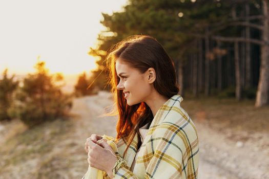 young woman near coniferous forest road plaid sunset. High quality photo