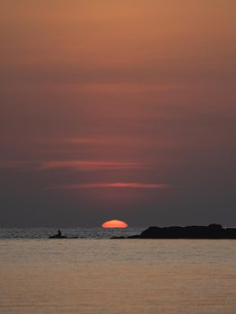 Sunset ocean view. Sun above the sea on orange sky.