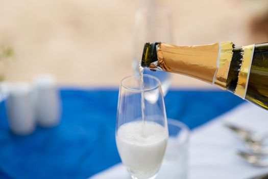 Close up : Bartender pouring champagne into glass.