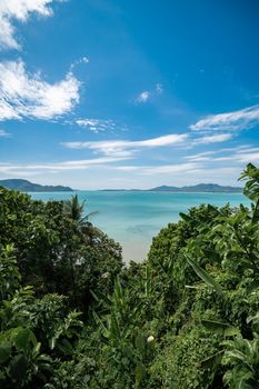 Tropical island with green trees on the foreground and beach, Phuket, Thailand.