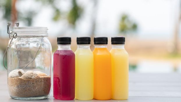 Healthy smoothies fruit and vegetable juice in bottles with sand in bottle