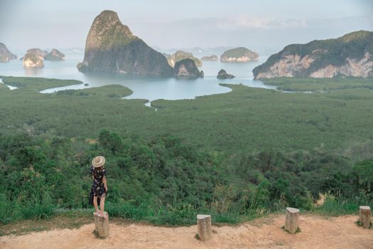 Samed Nang Chee. Woman with view of the Phang Nga bay, mangrove tree forest and hills at Andaman sea, Thailand.