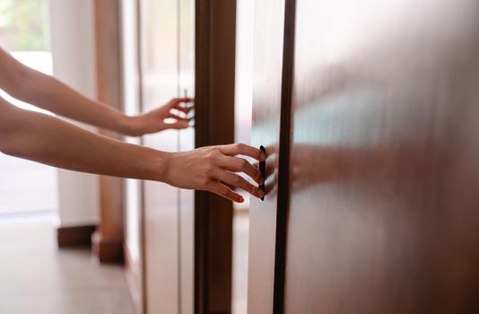 Close up women hand open the door knob or push the wooden door.