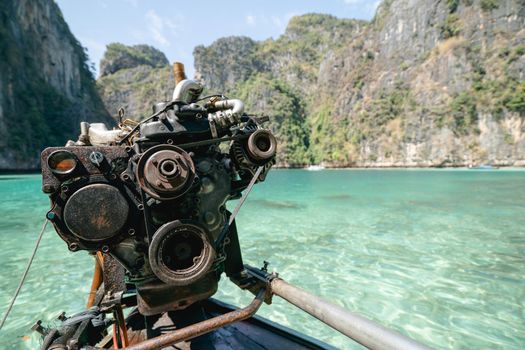 Old Machine of Fishing boat at the clear blue sea water in Thailand.