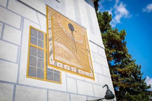 Sundial on the wall of the building of the historic town of Krumlov in the Czech Republic on a sunny summer day