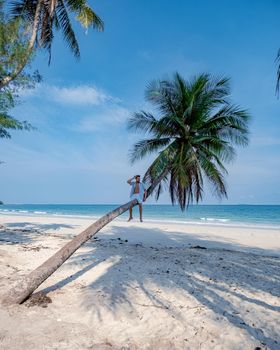 couple on vacation in Thailand, Chumpon province, white tropical beach with palm trees, Wua Laen beach Chumphon area Thailand, palm tree hanging over the beach with a couple on vacation in Thailand.