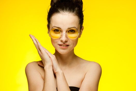 woman with bare shoulders wearing fashion glasses gathered hair. High quality photo