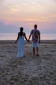 sunrise on the beach with palm trees, Chumphon Thailand, couple watching sunset on the beach in Thailand Asia, mean and woman mid age watching sunrise on beach