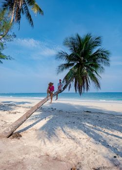 couple on vacation in Thailand, Chumpon province, white tropical beach with palm trees, Wua Laen beach Chumphon area Thailand, palm tree hanging over the beach with a couple on vacation in Thailand.