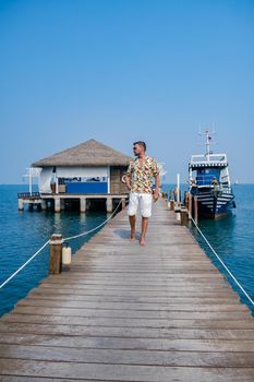 wooden pier in ocean Pattaya Bangsaray beach Thailand, a man walking on wooden pier during vacation Thailand. Asia