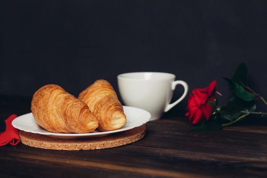 fresh croissant on a plate kitchen utensils coffee cup. High quality photo