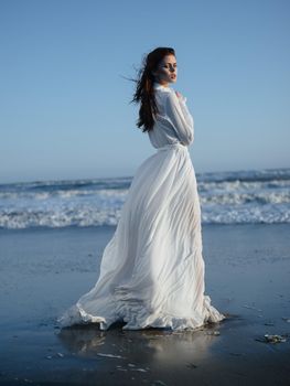 romantic woman in full length sundress by the ocean blue sky beach. High quality photo