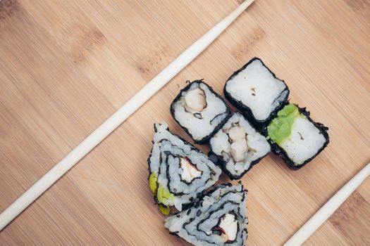sushi rolls chopsticks food ration delicacy wood board. High quality photo