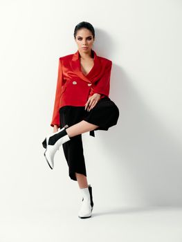 pretty woman red jacket Modern Studio leg bent at the knee luxury. High quality photo