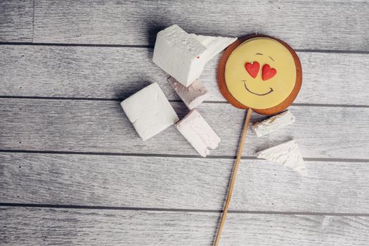 gingerbread in the form of a smiley on a stick marmalade sweets dessert enjoyment wooden background. High quality photo