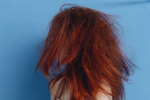 emotional woman with tousled hair on blue background tousled curls portrait. High quality photo